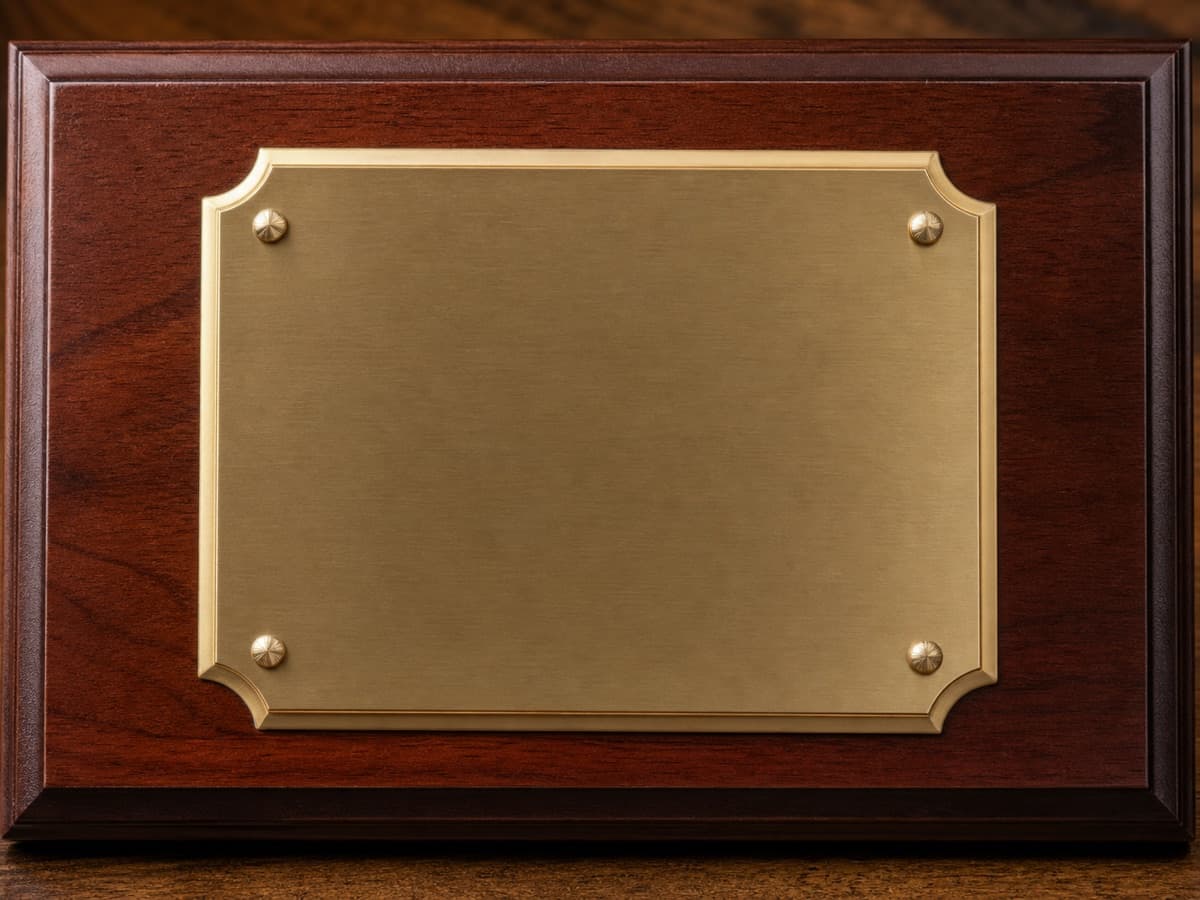 Illustrative close-up of cherry wood and a beveled brass-toned plaque plate