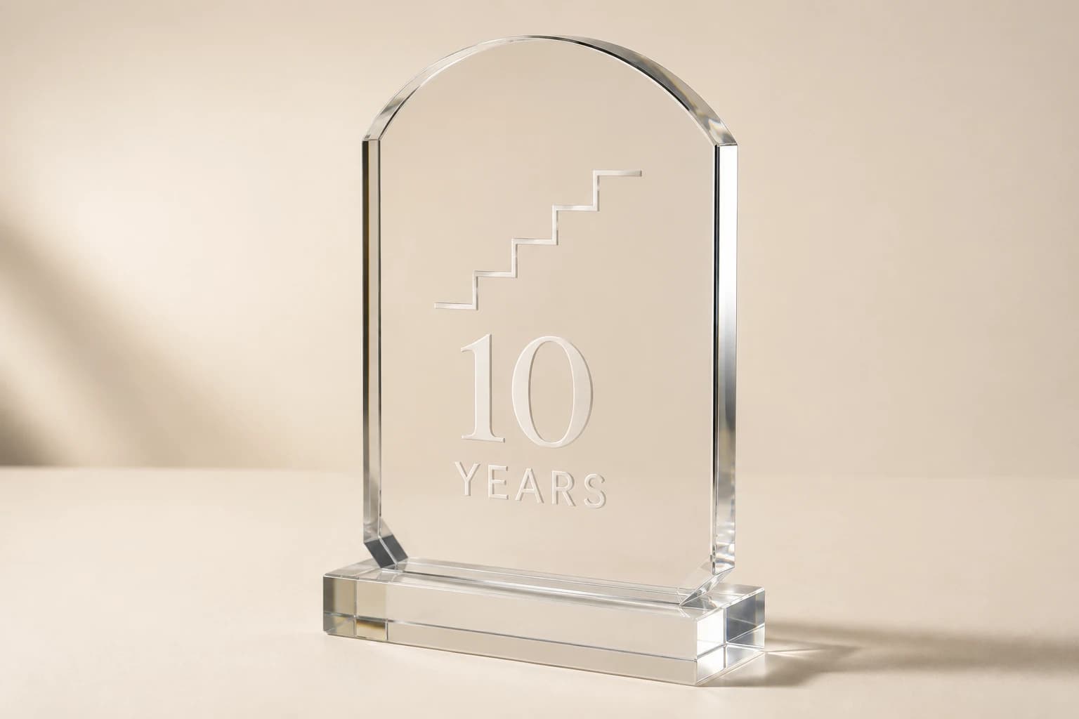 Clear acrylic milestone monolith with an arched top and service-year engraving.